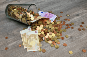 coins and paper bills spilling in glass